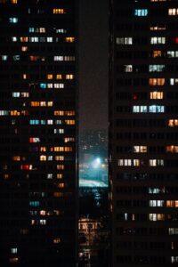 夜のオフィス街を窓越しに見る