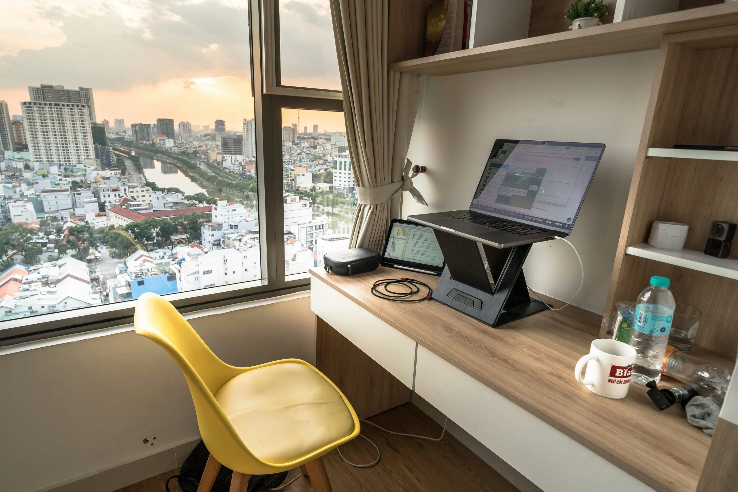 机の上のノートPCと窓の外の街