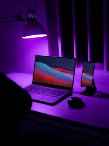 暗い部屋でデスクランプに照らされたノートPC