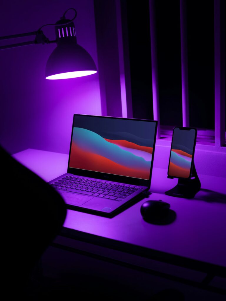 暗い部屋でデスクランプに照らされたノートPC