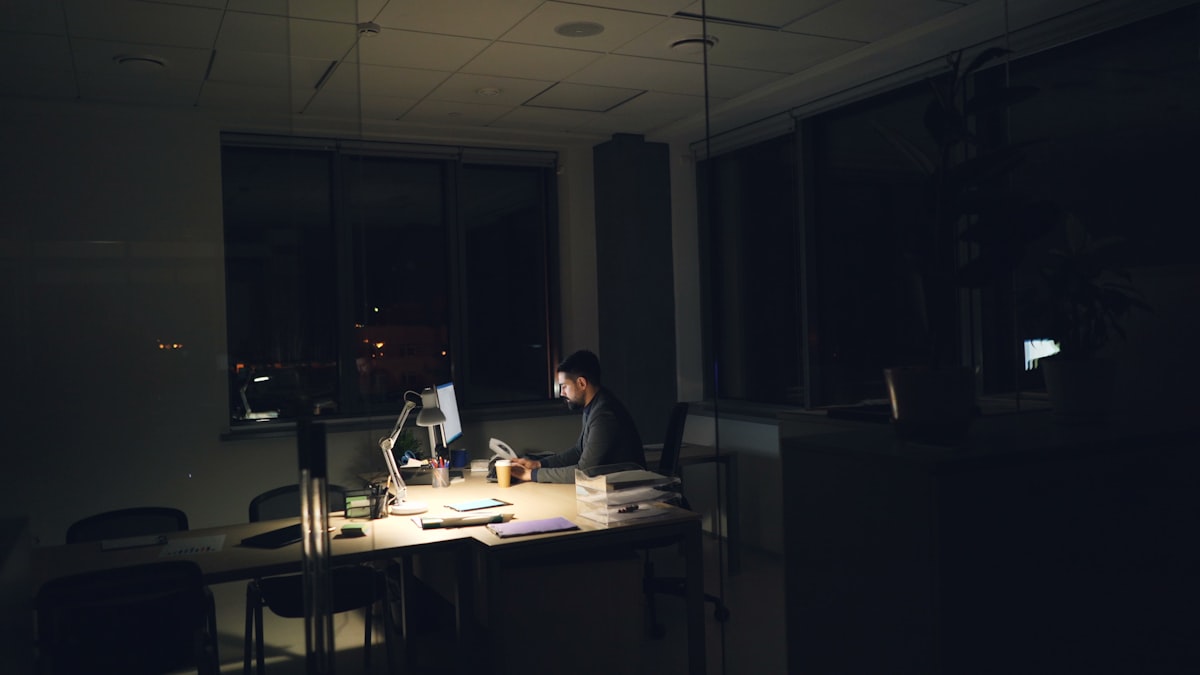 夜のデスクランプに照らされたPC