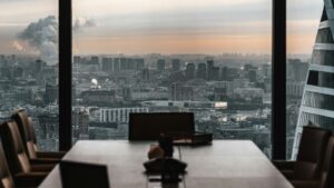 夕暮れの市街地を見下ろす窓際の会議室